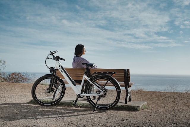 Man sitting on a bench beside an electric bike